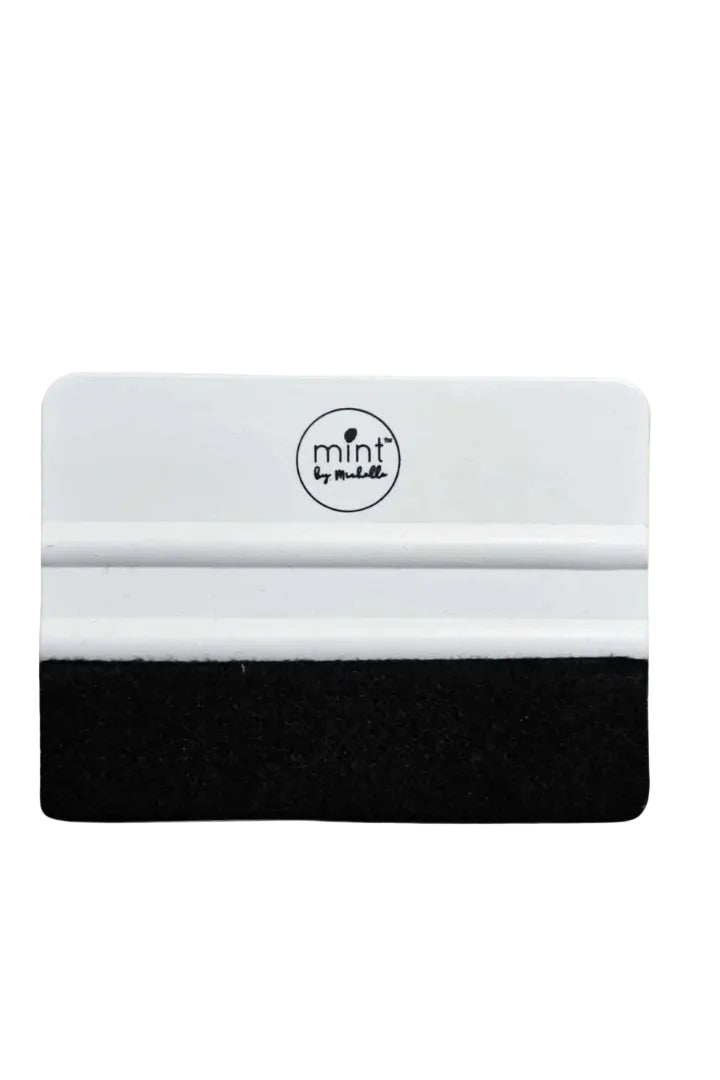 A white felt applicator tool with a black tip and the 'mint by michelle' logo on the top.