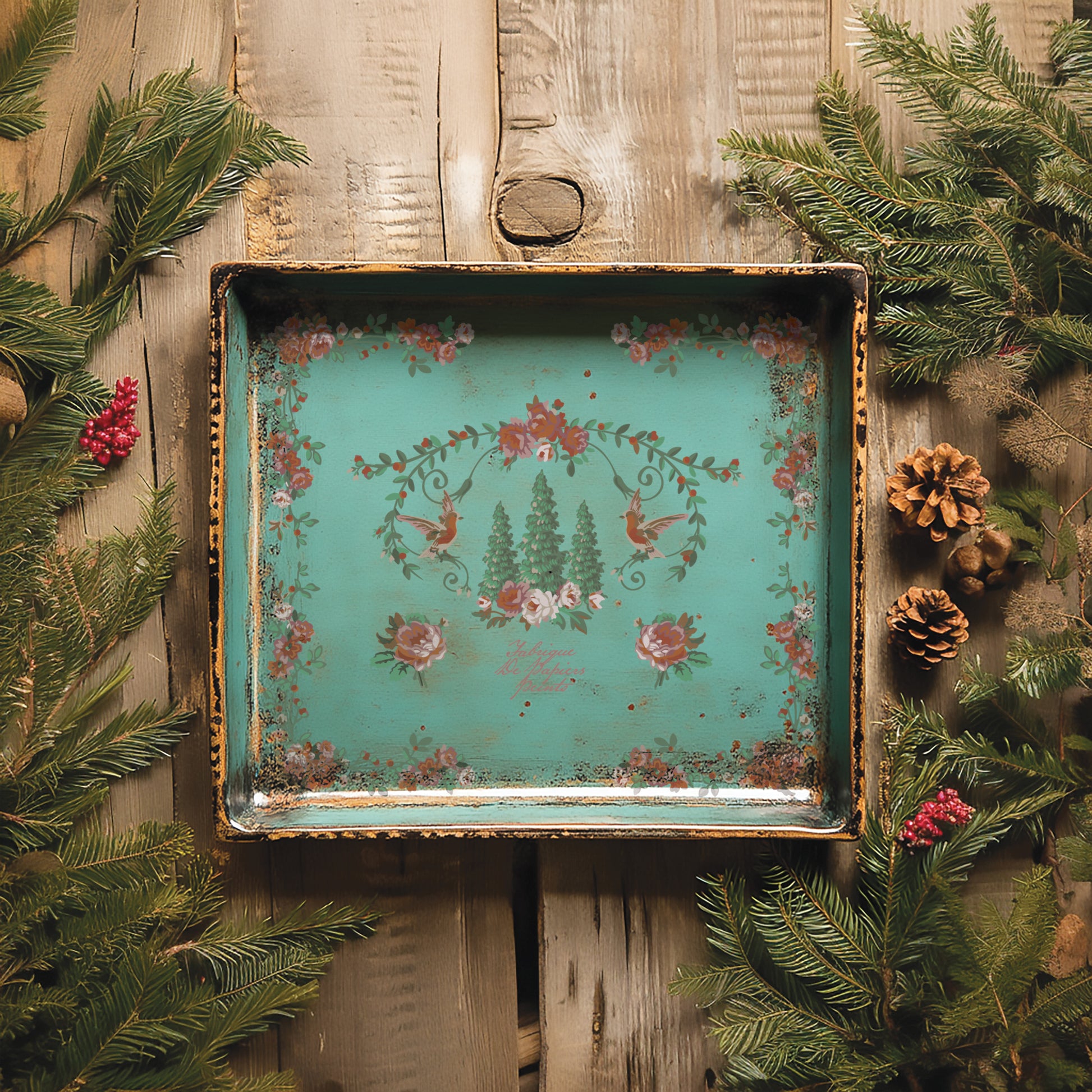 Decorative tray with floral design on a wooden background with greenery