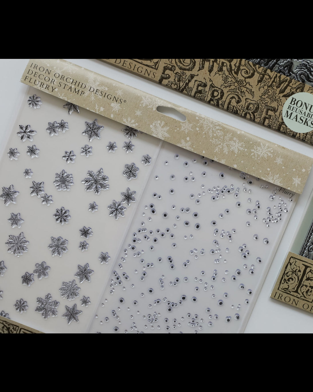 Iron Orchid Designs clear stamp set featuring decorative stamp blocks with silver snowflakes and rhinestones, shown alongside matching printed masks and a bonus mask insert.