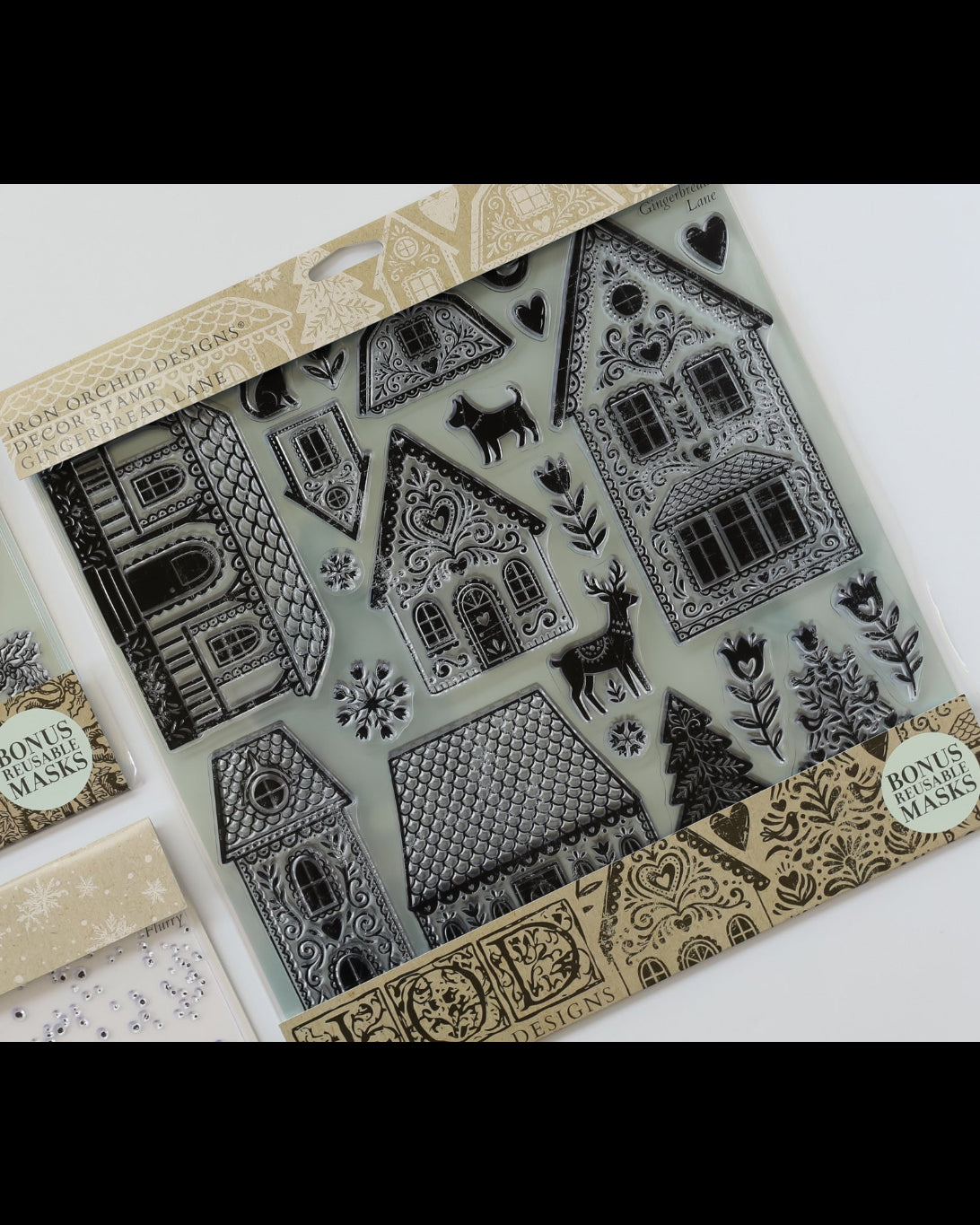 A package of black rubber stamp designs featuring Christmas houses, trees, snowflakes, and a reindeer, displayed alongside other stamp designs on a white background.