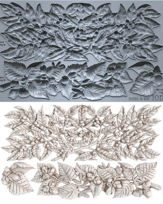 A gray silicone baking or craft mold sheet with embossed floral and leaf patterns, shown above a set of matching light beige carved floral and leaf pieces on a white background. Iron Orchid Designs Hazel and Bay 